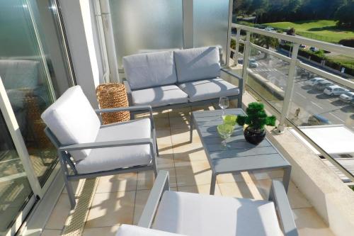 d'un balcon avec deux chaises et une table. dans l'établissement Bright T2 "Golf Panorama" air-conditioned parking golf view, à Biot