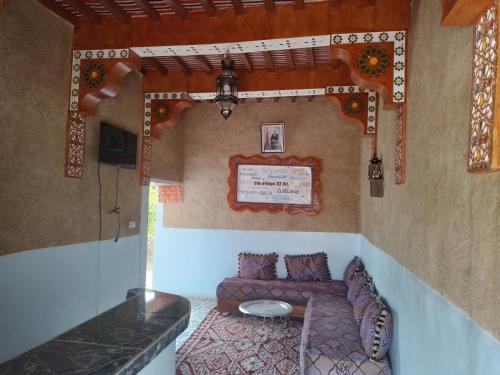 een kleine kamer met een bank en een tafel bij gîte d'étape ziz oasis in Achbarou