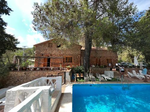 a house with a swimming pool in front of a house at Casa Rural Los Parrales in El Tranco