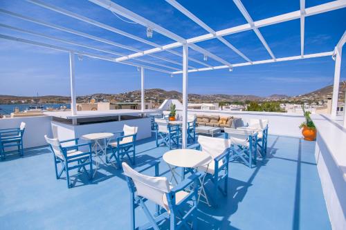 a patio with tables and chairs and a bar at Porto Bello di Paros in Parikia