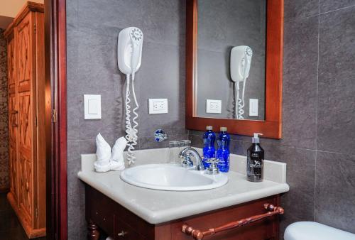 a bathroom with a sink with a phone on the wall at Uzhupud Garden Hotel & Lodge in Paute