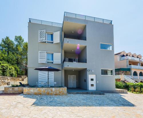 a large building with an umbrella in front of it at Studio Apartment Stela in Vrboska