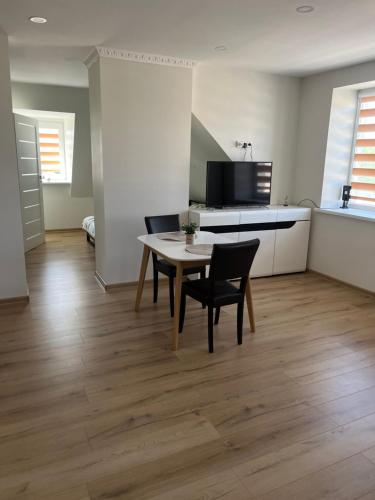 eine Küche und ein Esszimmer mit einem Tisch und Stühlen in der Unterkunft Centro apartamentai in Kalvarija