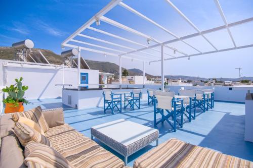 a patio with a couch and chairs and a bar at Porto Bello di Paros in Parikia