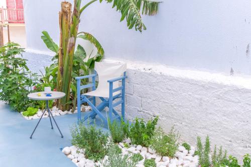 a blue chair and a table in a garden at Porto Bello di Paros in Parikia