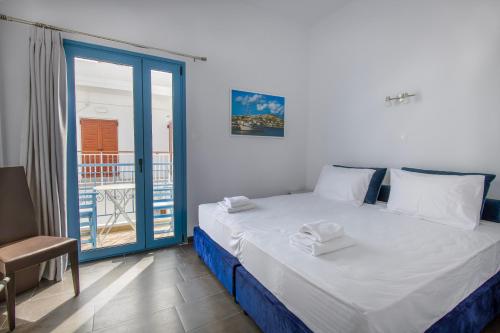 1 dormitorio con 1 cama y puerta corredera de cristal en Porto Bello di Paros en Parikia