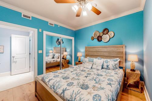 a bedroom with blue walls and a bed and a fan at Holiday Isle 715 in Dauphin Island