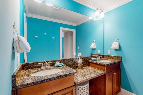 a bathroom with two sinks and a large mirror at Holiday Isle 715 in Dauphin Island