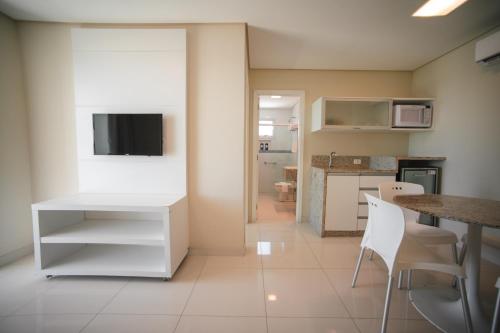 a kitchen with a white desk and a table and chairs at Slaviero Ingleses Convention in Florianópolis