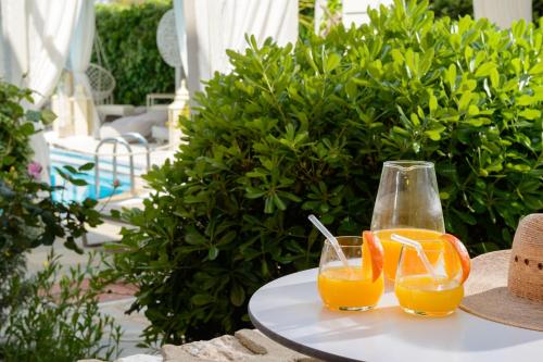 two glasses of orange juice sitting on a table at Nikoleta Hotel and Villas in Limenas