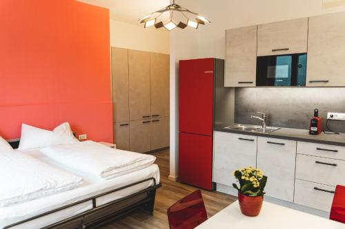 Habitación pequeña con cama y cocina en Lux - Studio-Appartment, en Merano