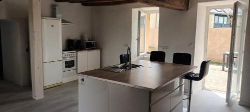 une cuisine avec un îlot et un comptoir dans l'établissement Maison de campagne, à Seiches-sur-le-Loir
