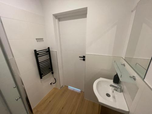 a white bathroom with a sink and a mirror at RedDoor Zator Lake Houses in Zator