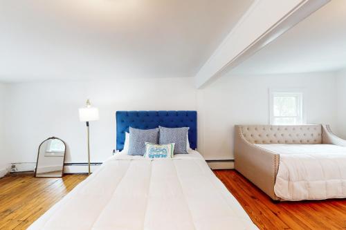 - une chambre avec un grand lit blanc et une tête de lit bleue dans l'établissement Seas The Bay, à Annapolis