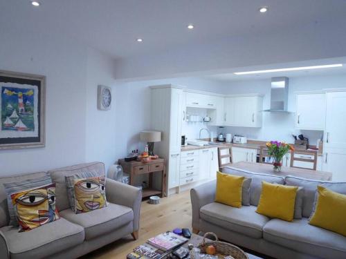 a living room with two couches and a kitchen at Apartment with Roof Terrace - Centre of Yarmouth in Yarmouth