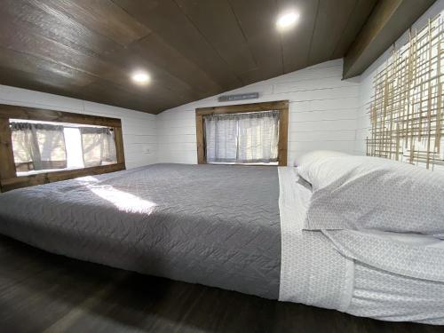 a bedroom with a large bed and two windows at Tiny House Leadville Colorado in Leadville