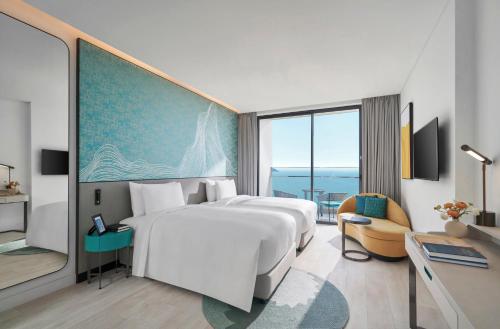 a hotel room with two beds and a window at voco Ma Belle Danang by IHG in Da Nang