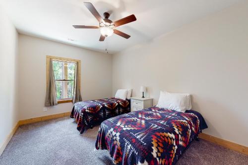 a bedroom with two beds and a ceiling fan at Woodstone Trail Tranquility in Ellijay