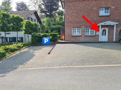 uma seta vermelha a apontar para um parque de estacionamento em frente a um edifício em Ferienwohnung in Ruppichteroth Winterscheid em Ruppichteroth