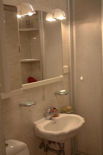 a bathroom with a sink and a mirror and a toilet at Sunny Studio blisko plaży in Sopot