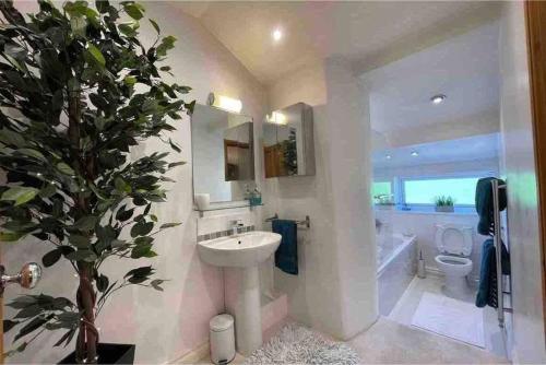 a bathroom with a sink and a tub and a toilet at Brook Cottage in the heart of Yorkshire in Baildon