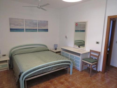 a bedroom with a bed and a desk and a chair at Appartamento Oberdan in Milano Marittima