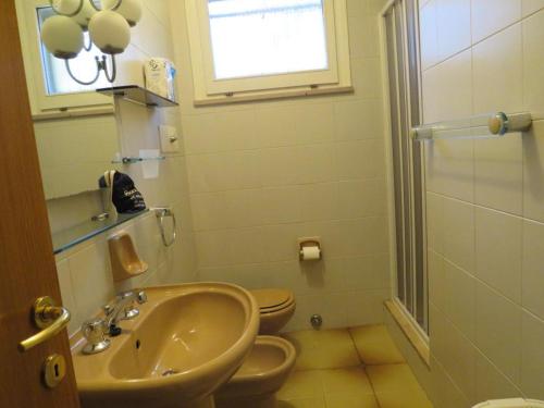 a bathroom with a sink and a toilet and a window at Appartamento Oberdan in Milano Marittima