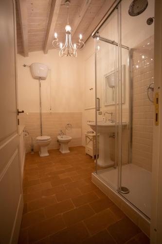 a bathroom with two toilets and a shower and a chandelier at Villa Nena in Tolentino