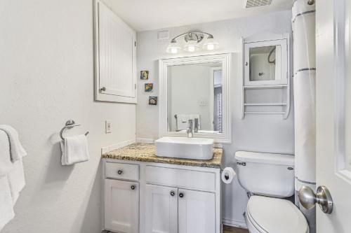 Baño blanco con lavabo y aseo en Casa Del Sol, en Padre Island