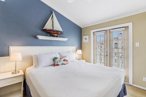 a bedroom with a white bed and a sailboat on the wall at Casa Del Sol in Padre Island
