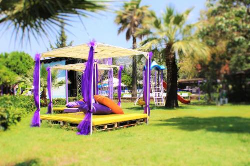 a playground with a swing set in a park at PİGALE BEACH RESORT in Kuşadası