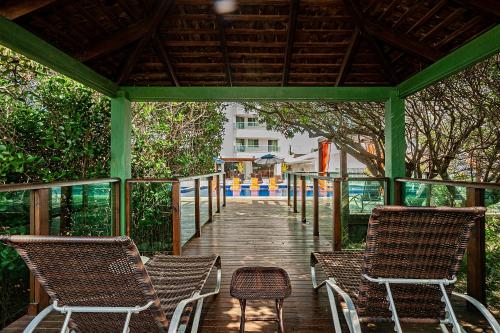 a wooden boardwalk with two chairs and a gazebo at Slaviero Ingleses Convention in Florianópolis