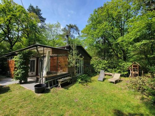 a small cabin in the middle of a yard at Bungalow in het bos in Nunspeet