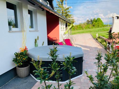 a patio with a table and plants in front of a house at Relax Home ®Rajna® in Korenica