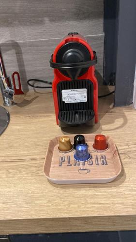 un mixeur rouge assis au-dessus d'une table en bois dans l'établissement Toulouse centre 4 couchages, à Toulouse