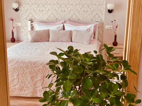 Schlafzimmer mit einem Bett mit rosa und weißen Kissen in der Unterkunft Tamerlan in Chmelnyzkyj