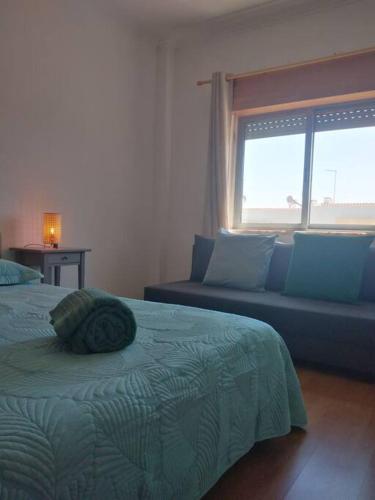 una camera da letto con un letto, un divano e una finestra di Navigation House a Sesimbra