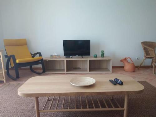 a living room with a tv and a coffee table at Navigation House in Sesimbra