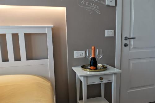 a bedroom with a bed and a table with a bottle of wine at Vicolo Fiore Affittacamere II in Matera