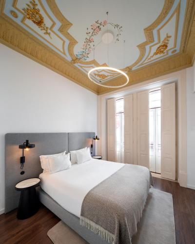 a bedroom with a large bed with a ceiling at O Paço - exclusive accommodation in Tomar