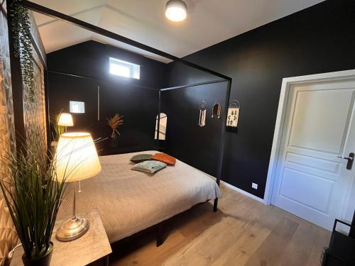 1 dormitorio con 1 cama con pared negra en Gîte "Le Loft", en Chamblet
