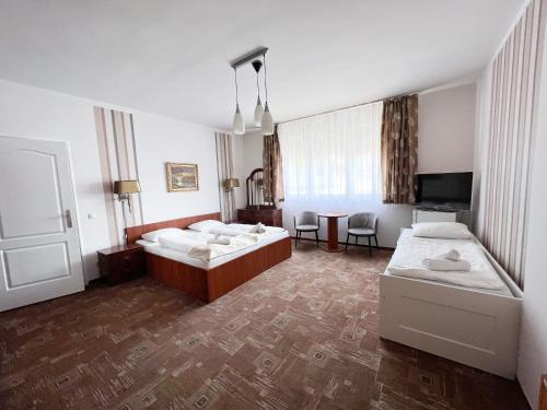 Cette chambre comprend 2 lits et une télévision. dans l'établissement Wolf Panzió, à Sárvár