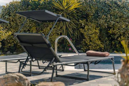 a table and chair sitting next to a swimming pool at Propodes Luxury Villa in Pastida