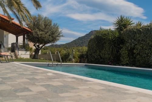 a swimming pool in front of a house with a mountain at Propodes Luxury Villa in Pastida