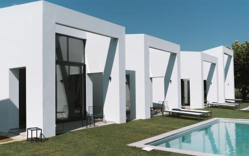 une maison blanche avec une piscine dans la cour dans l'établissement Sevene Villas, à Petroúlai