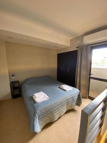 1 dormitorio con 1 cama con 2 toallas en Alquiler Temporario JPE Tunuyan en Tunuyán