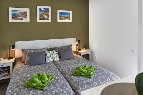 ein Schlafzimmer mit einem Bett mit zwei grünen Blättern darauf in der Unterkunft Casa de Cactus in Tarajalejo