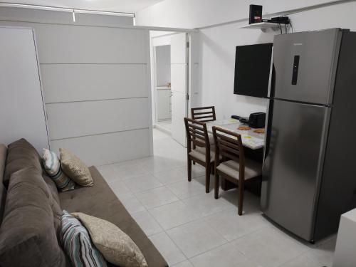 eine Küche mit einem Kühlschrank und einem Tisch mit Stühlen in der Unterkunft Ap no centro de Florianopolis in Florianópolis