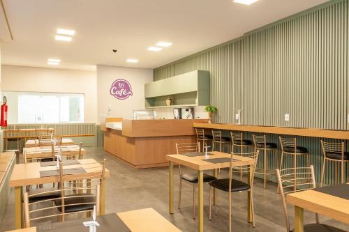a restaurant with tables and chairs and a counter at Tri Hotel Executive Osório in Osório