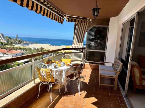 een balkon met een tafel en stoelen en de oceaan bij Vista al mar - Piscina by VV Canary Ocean Homes in Los Cristianos